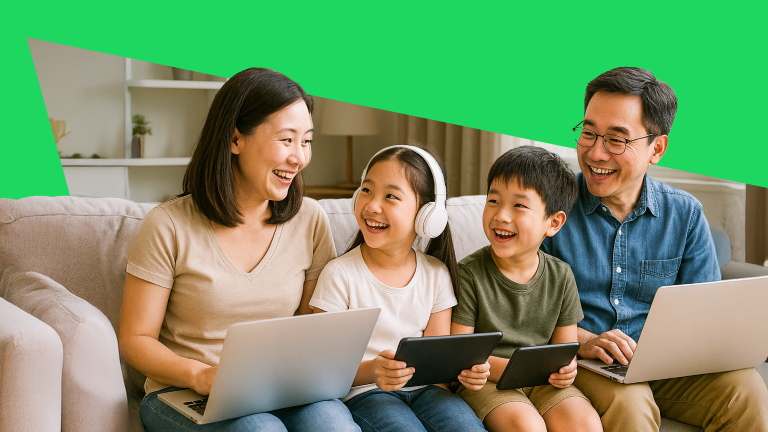 A family sitting on the couch with laptops in mother and father's laps